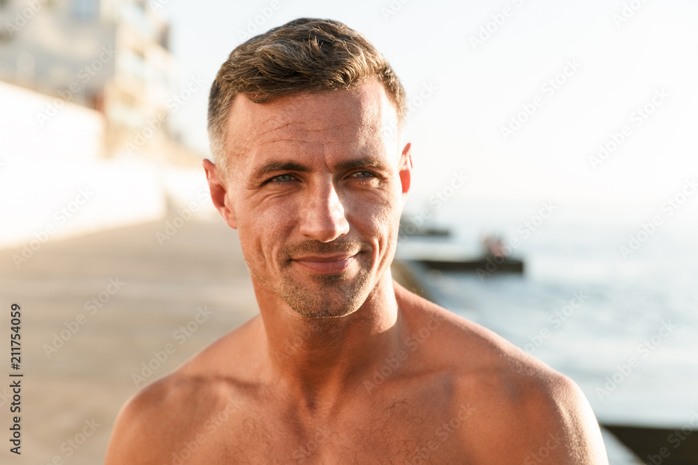 Close up of smiling shirtless sportsman at the beach Close up of smiling shirtless sportsman at the beach
