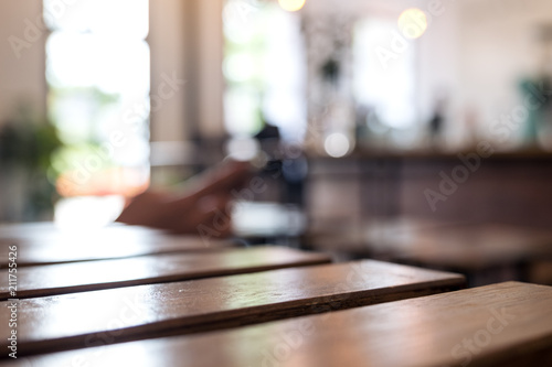 Wooden table and chair in cafe with blur bokeh abstract vintage background