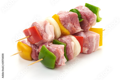 Skewers with pieces of raw meat, red, yellow and green bell pepper, seasoned with coarse salt and olive oil, isolated on white background. Close-up. photo