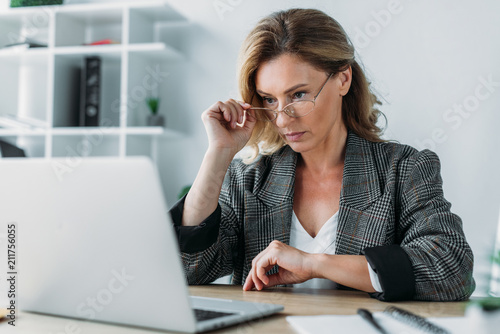 attractive businesswoman working in office with notebook and laptop