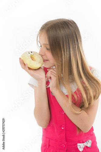 Child look at donut isolated on white. Little girl with glazed ring doughnut. Kid with junk food. Unhealthy eating and snack food. My favorite meal