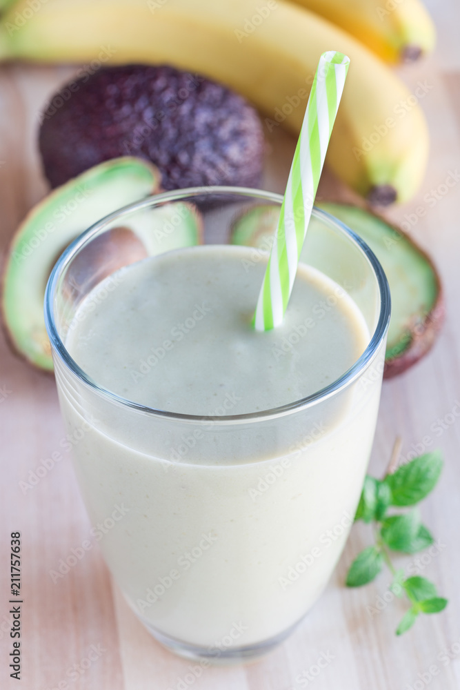 Smoothie with avocado, banana, milk and honey on wooden background, vertical Smoothie with avocado, banana, milk and honey on wooden background, vertical