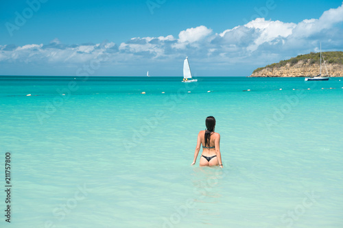 Girl swimwear azure crystal ocean water rear view. Vacation luxury ocean beach resort. Swim through magical turquoise lagoon. Woman sexy body relaxing ocean beach Antigua. Enjoy paradise