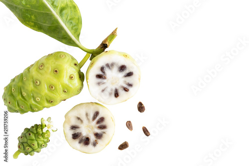 Noni fruit or Morinda Citrifolia and noni slice with seed and green leaves of the noni isolated on white blackground with copy space for text. Top view.