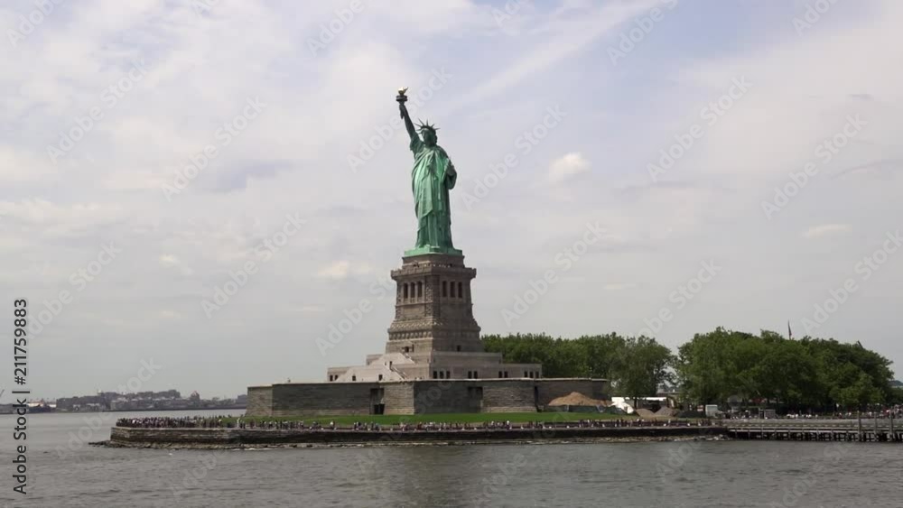 Wide close view passing by the Statue Of Liberty by boat on a sunny summer day. Wide close view passing by the Statue Of Liberty by boat on a sunny summer day.