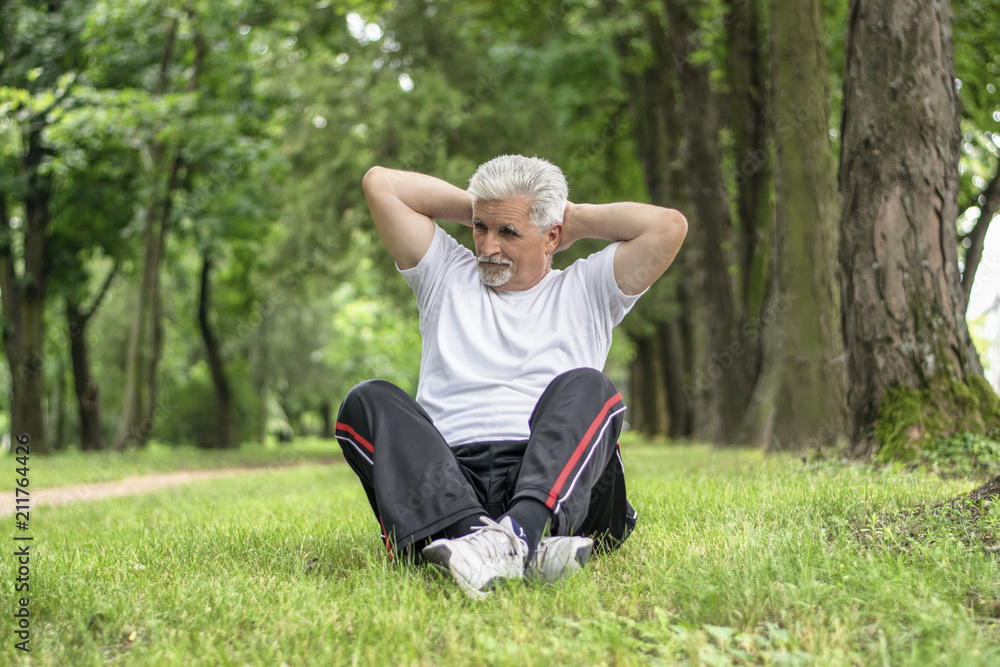 Senior man stretching after jogging in the park Senior man stretching after jogging in the park