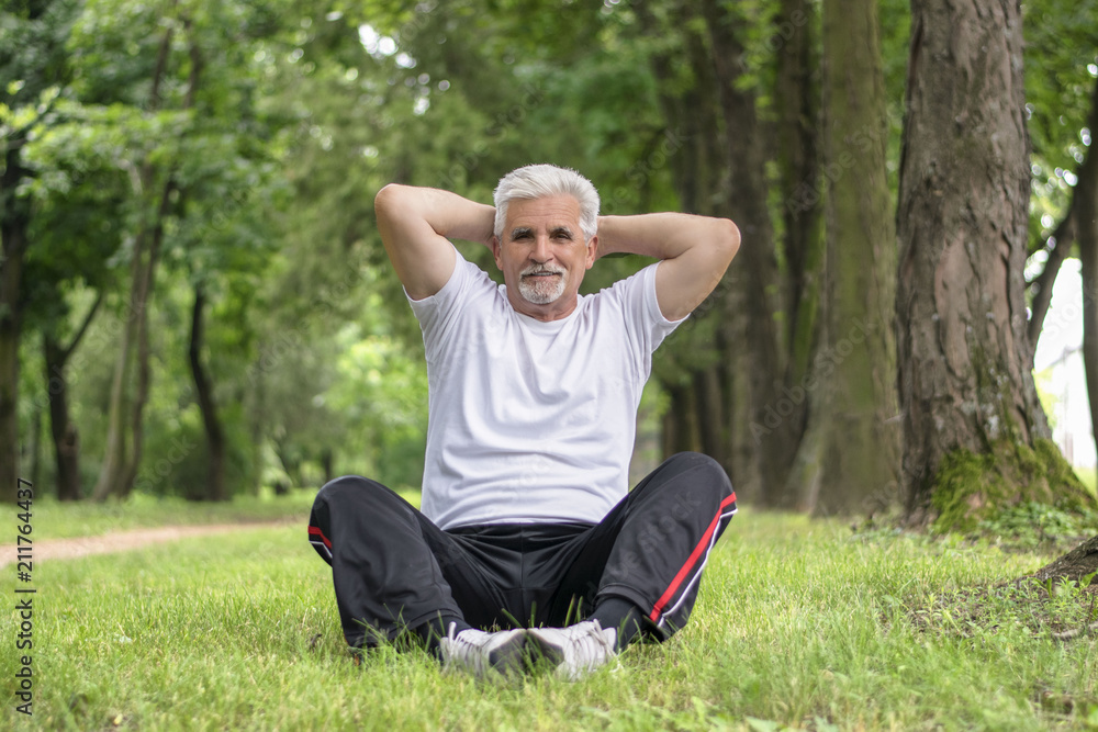 Senior man stretching after jogging in the park Senior man stretching after jogging in the park