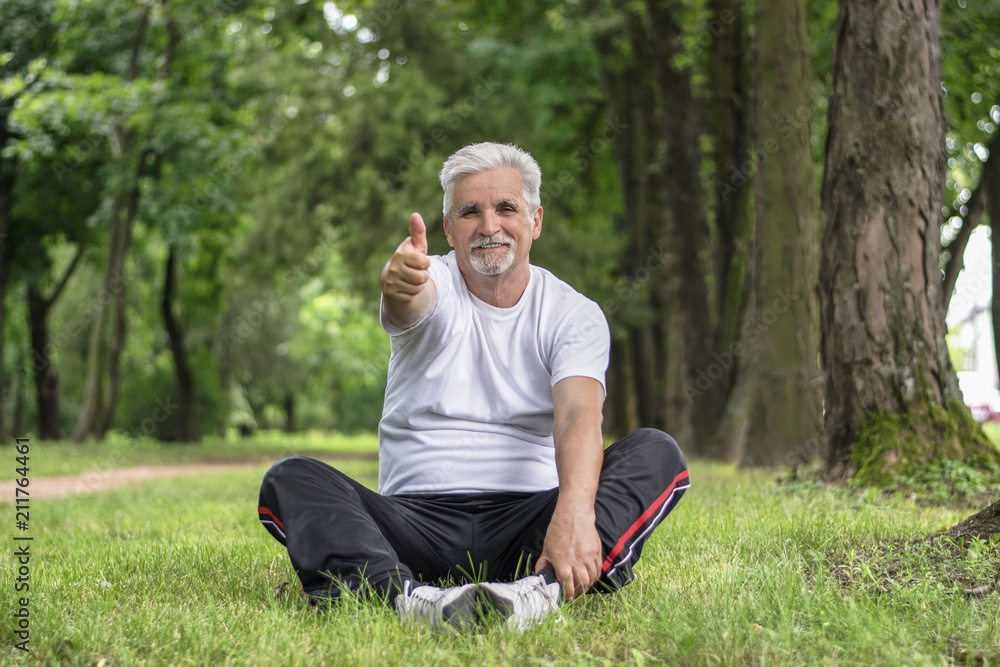 Senior man stretching after jogging in the park Senior man stretching after jogging in the park