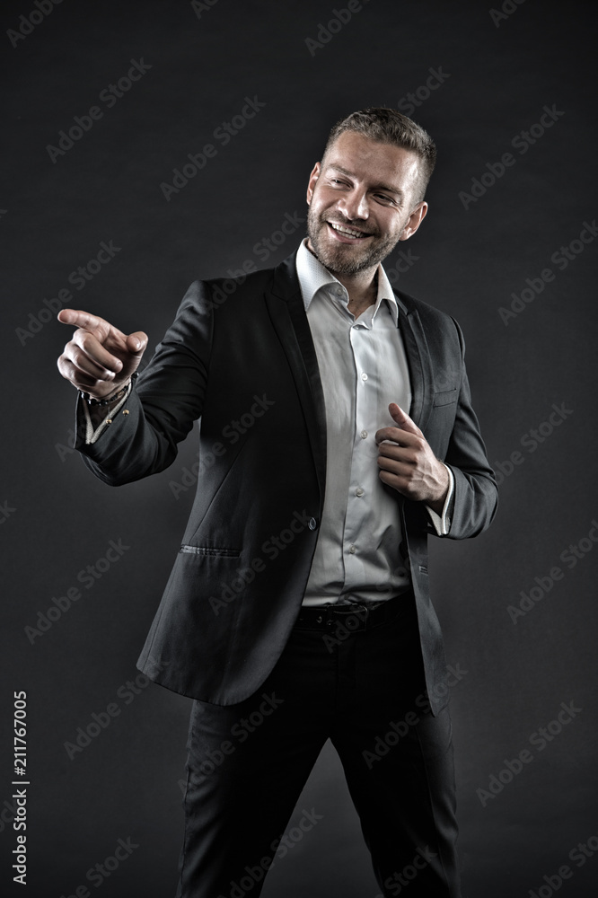 Man with big smile on face isolated on black background. Guy with three day beard wearing smart suit and white shirt. Comedian doing performance, fun concept. Office clerk with cool gesture