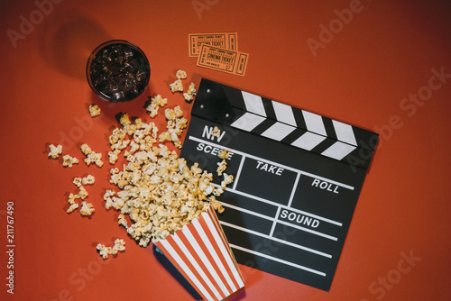 watching movie with popcorn on red background top view.
