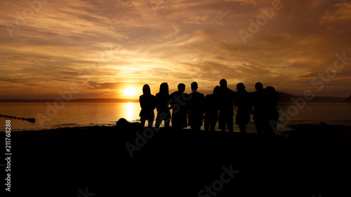 Black silhouette of a crowd of people at sunset