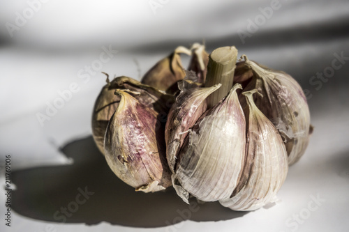 Fresh garlic on white background. Garlic cloves. Peeled garlic bulbs on jute. photo