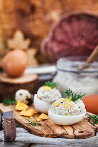 Eggs stuffed with herring creamy pate on wooden rustic background