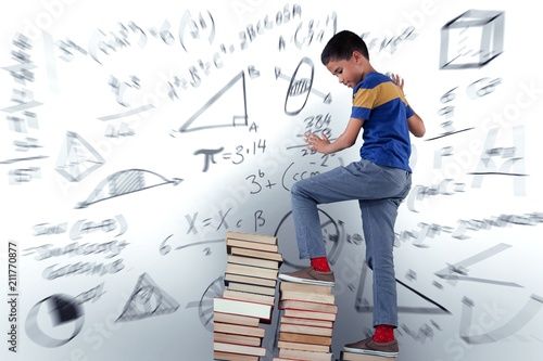 Composite image of schoolboy climbing stack of book