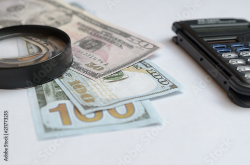 The concept of lending. Money, calculator, magnifier.