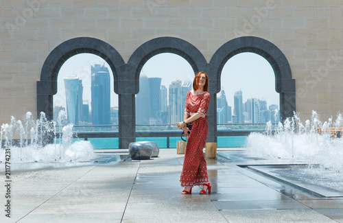 Girl opposite the skyscrapers and the sea in Doha.