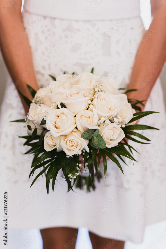 Bridal bouquet held by her with her hands at her wedding