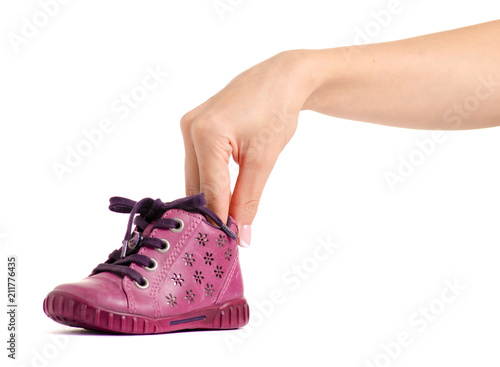 Children's pink shoe in hand on a white background isolation