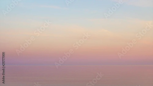 Majestic sunset in pastel tones over calm water. Looped seamless video.
