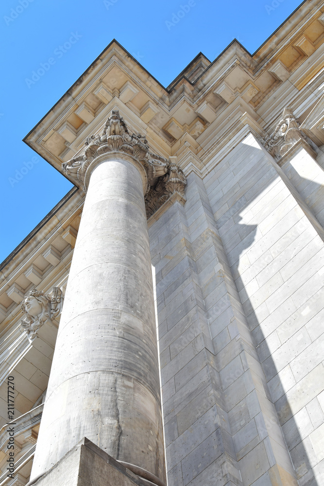 Columns and decorated architectural detail of German parliament (Reichstag - Bundestag) in Berlin closeup against blue sky.