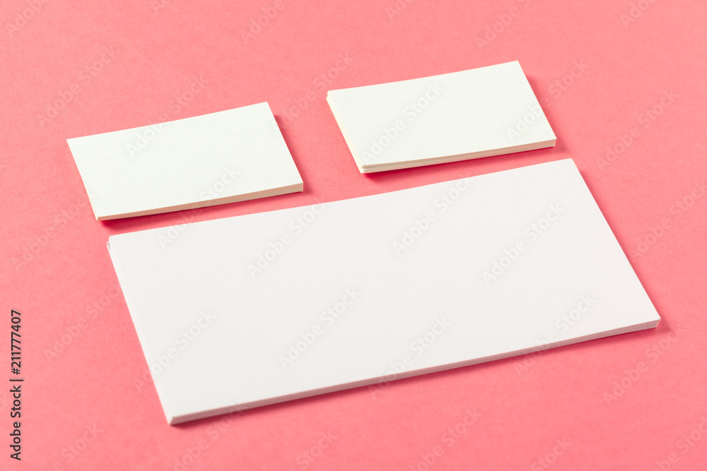 Blank paper pieces on a colored pink background Blank paper pieces on a colored pink background