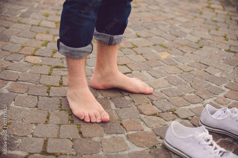 barefooted man standing in street at his white gumshoes barefooted man standing in street at his white gumshoes