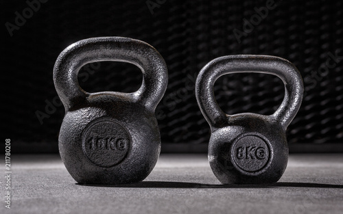 Two dumbbels with steel background in sportclub, 16kg and 8 kilograms