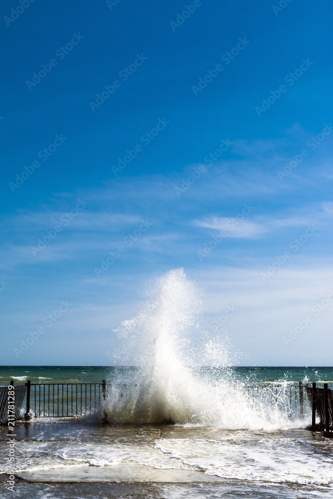 Sea water splashes at old pier on sunny day Sea water splashes at old pier on sunny day