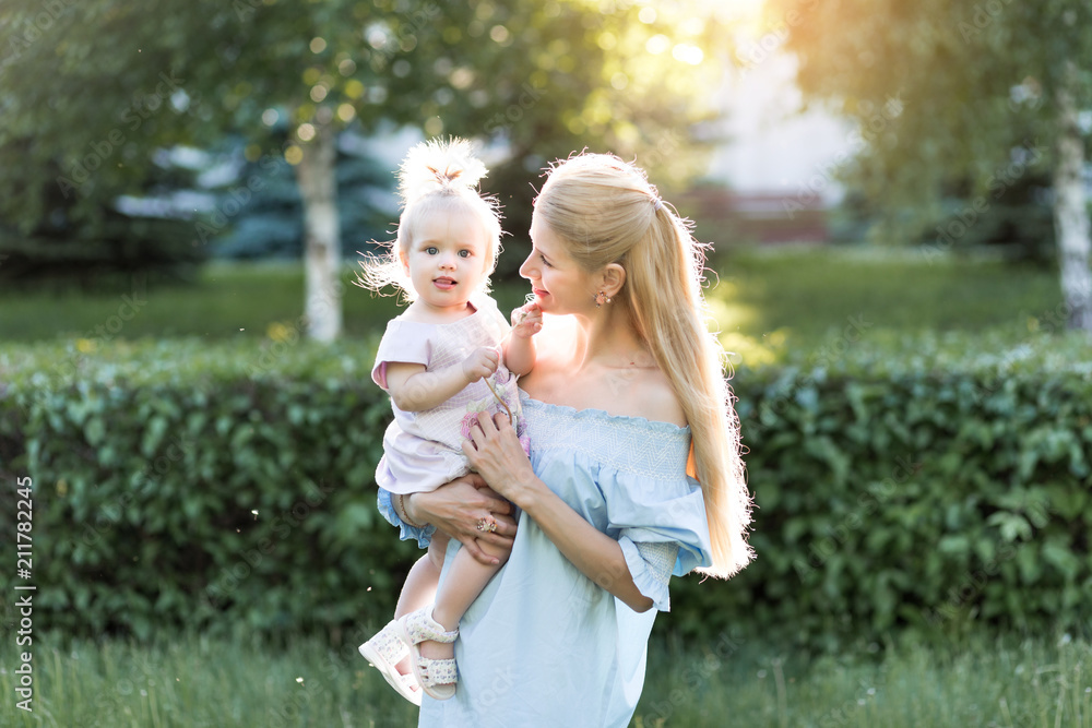 happy harmonious family outdoors. mother throws baby up, laughing and