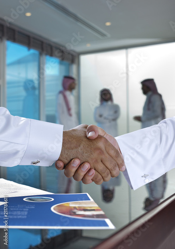 Saudi Arab businessmen shaking hands, and making agreement or a deal