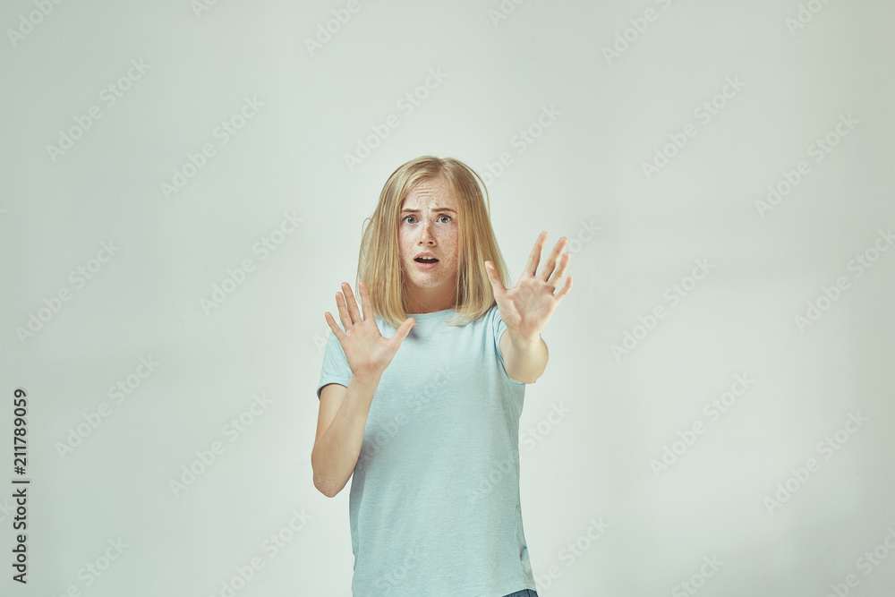 Fototapeta premium Portrait of the scared woman on gray