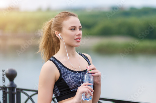 young beautiful girl holding a bottle of cool water for drinking photo