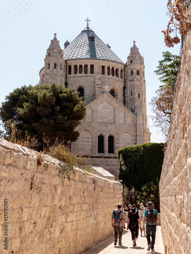 Tourists walk along the passage along the narrow street Ma'ale HaShalom to the Dormition abbey in old tow in Jerusalem photo