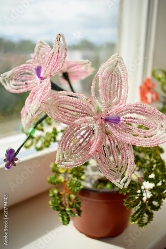 beautiful pink flower of beads on the window-sill