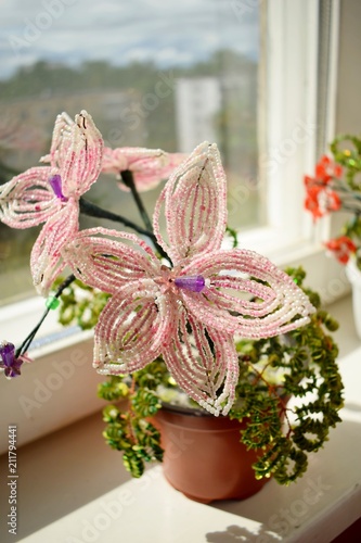beautiful pink flower of beads on the window-sill