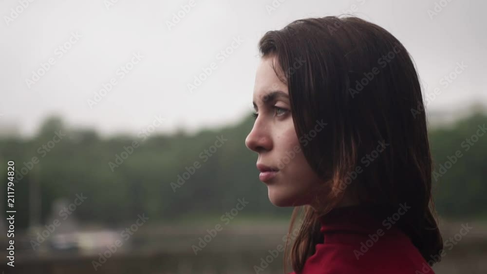 Young sad woman with wet hair looking away, cloudy rainy weather Young sad woman with wet hair looking away, cloudy rainy weather
