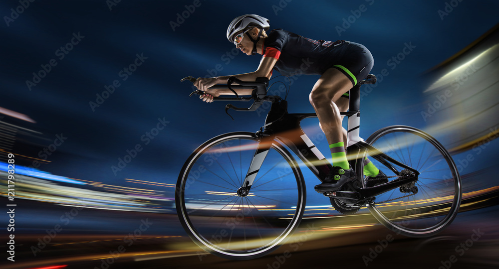 Sport background. Athletic woman cycling road bike in the evening. Dramatic  view of the night city. Stock Photo | Adobe Stock