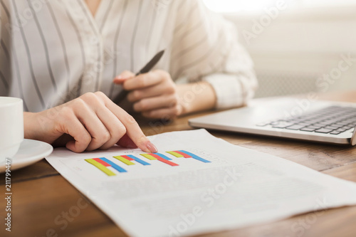 Woman analyzing business statistics holding diagrams