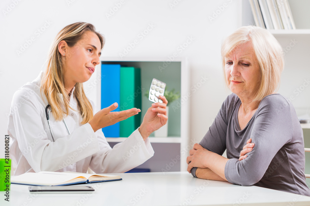 Senior woman patient refusing to take pills for her health problems. Senior woman patient refusing to take pills for her health problems.