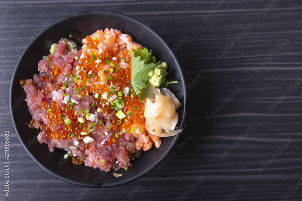 Premium fresh raw seafood mixed rice bowl (Kaisen-don/ Japanese tasty food), Japanese Rice with sashimi of tuna, Maguro, Otoro, salmon and ikura (Salmon eggs) on wood background Premium fresh raw seafood mixed rice bowl (Kaisen-don/ Japanese tasty food), Japanese Rice with sashimi of tuna, Maguro, Otoro, salmon and ikura (Salmon eggs) on wood background