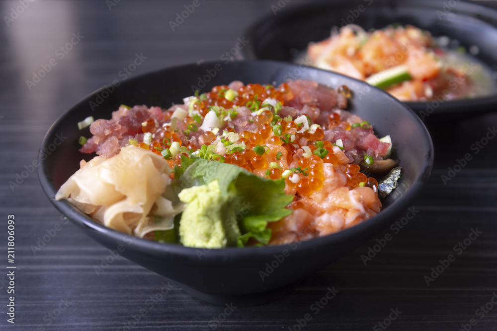Premium fresh raw seafood mixed rice bowl (Kaisen-don/ Japanese tasty food), Japanese Rice with sashimi of tuna, Maguro, Otoro, salmon and ikura (Salmon eggs) on wood background