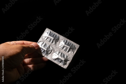 hand holding tablet of pills