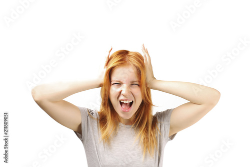 Beautiful redheaded young woman experiencing severe migraine writhing with pain. Pretty female feeling headache holding head. Nonverbal behavior, body language. White background, close up, copy space.