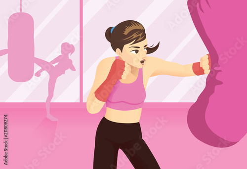 Woman tried a boxing workout with punching heavy bag with gym background.