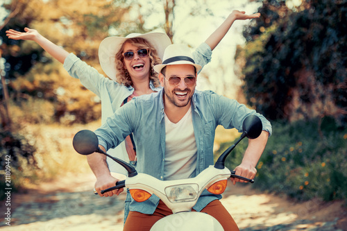 Happy young couple riding a scooter