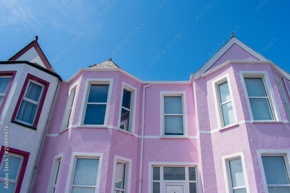 Fototapeta premium colorful pink house against blue sky in whitehead northern ireland