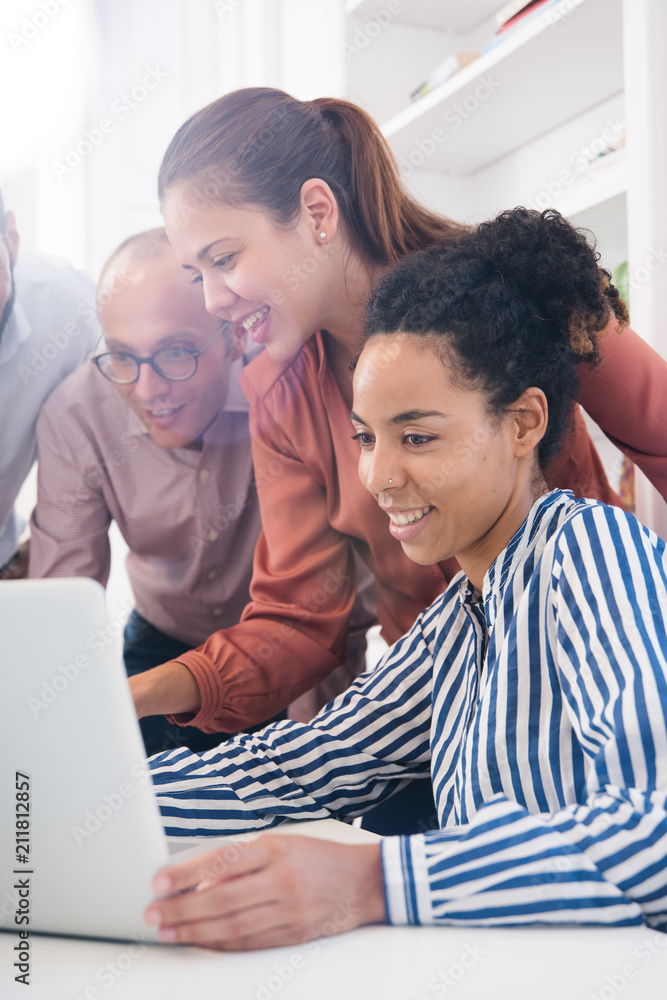 Three business people around a laptop Three business people around a laptop