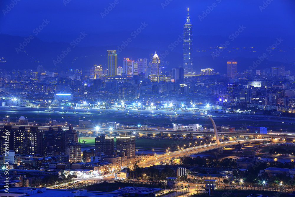 Aerial panorama of busy Taipei City, Keelung River, Dazhi Bridge, Songshan Airport & Taipei 101 in XinYi District at dusk ~ A romantic evening of Taipei downtown with beautiful twilight in the sky