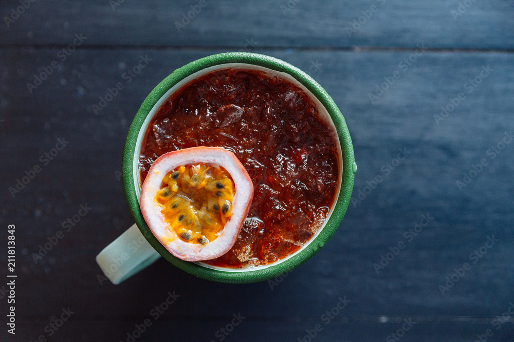 Top view of Iced Passion fruit juice served in zinc cup with a cut half of fresh passion fruit. Top view of Iced Passion fruit juice served in zinc cup with a cut half of fresh passion fruit.