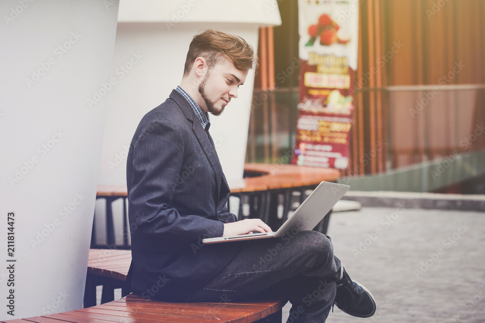 Portrait of young businessman using laptop in modern coffee shop outdoor Portrait of young businessman using laptop in modern coffee shop outdoor